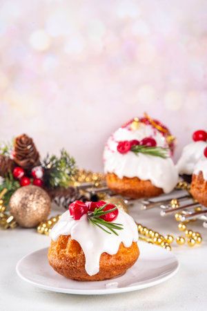 Portioned Christmas baked dessert, gingerbread chocolate and vanilla mini Christmas bundt cake with sugar glaze topping, cranberry and rosemary decorの写真素材