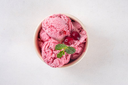 Homemade cranberry ice cream, creamy winter berry gelato with fresh cranberry and mint sprig in ceramic bowlの写真素材