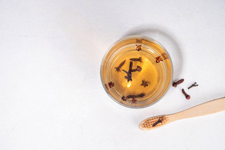 Clove Mouthwash with toothbrush on white table, Ayurvedic, antiseptic, anti-inflammatory and antioxidant Mouthwash, with organic Clove oilの写真素材