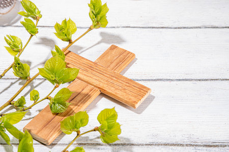 Easter orthodox catholic Christian  holiday background, with wooden cross symbol of religion, baking Easter cake with sugar icing, colored painted eggs and spring branches with blossoming leavesの写真素材