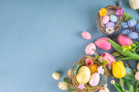 Spring Easter holiday table still life with painted Easter eggs, spring flowers bouquet, decorative bunny rabbits, on white kitchen backgroundの写真素材