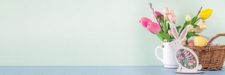 Spring Easter holiday table still life with painted Easter eggs, spring flowers bouquet, decorative bunny rabbits, on white kitchen backgroundの写真素材
