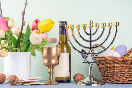 Pesah and Passover Jewish Spring holiday background with spring tulip flowers, decorative Easter eggs, wine bottle and glass, matzah flatbread, nuts and menorah on colorful backgroundの写真素材