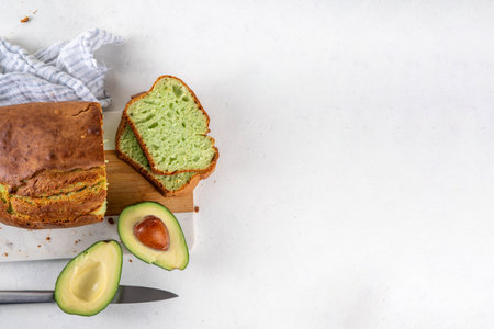Homemade avocado loaf of bread, keto diet recipe, healthy alternative food idea, on white kitchen background with fresh avocado, copy spaceの写真素材