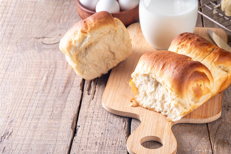 Japanese bread Shokupan, Hokkaido milk bread, or simply milk fluffy buns, on kitchen table, copy...