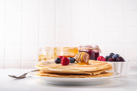 Traditional Maslenitsa food, Eastern European Slavic thin pancakes crepes, with various sweet spreads, toppings and fillings - honey, berries, jamsの写真素材