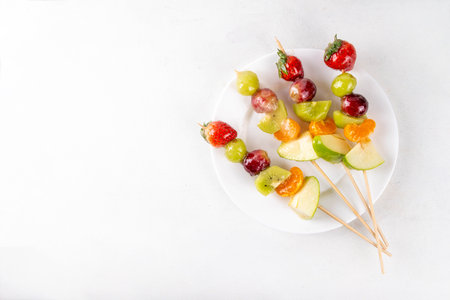 Traditional Chinese sweet street food recipe Tanghulu, fruit skewer on stick with crunchy sugar glaze, easy healthy dessert. Step by step preparation of Tanghulu with ingredients on table, top viewの写真素材