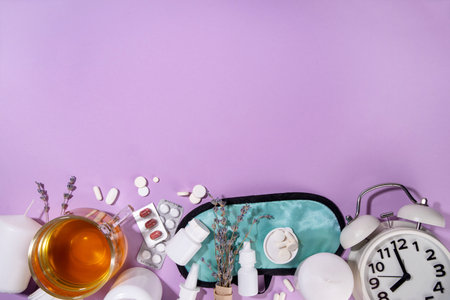 Sleep quality improvement concept, with sleep mask, relaxing herbal tea, lavender, alternative medicine pills for treating sleep disorderの写真素材
