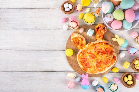 Cute Easter pizza for children brunch or party, pizza with  in form of bunny head and Easter eggs, with vegetables, cheese and tomato sauce,の写真素材