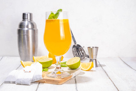 Trendy Tea Inspired cocktail set from green, oolong, black, chai and other tea blends. Sparkling tea soda, cold summer drinks with syrup, lemon, lime and mint, on sun lighted white wooden backgroundの写真素材