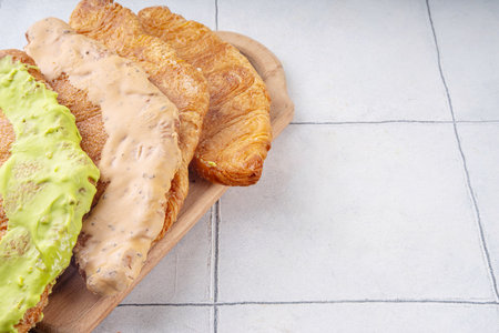 Set of colorful trendy flat croissants with different topping and fillings. Flat vanilla, pistachio, chocolate croissant, modern baked sweet dessert pastryの写真素材