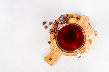 Fresh brewed ginger coffee cup. Dark coffee espresso hot drink with ginger powder and ginger root, on white background. Healthy hot drink. alternative medicine, remedyの写真素材