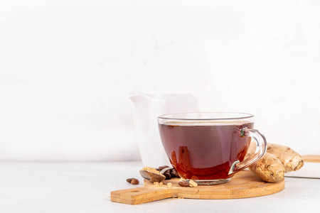 Fresh brewed ginger coffee cup. Dark coffee espresso hot drink with ginger powder and ginger root, on white background. Healthy hot drink. alternative medicine, remedyの写真素材