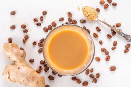 Fresh brewed ginger coffee latte cup. Creamy hot drink with ginger powder and ginger root, on white background. Healthy hot beverage. alternative medicine, remedyの写真素材