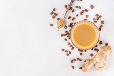 Fresh brewed ginger coffee latte cup. Creamy hot drink with ginger powder and ginger root, on white background. Healthy hot beverage. alternative medicine, remedyの写真素材