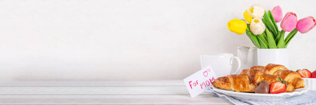 Motherâ€™s Day breakfast background featuring croissant, strawberries, chocolates, coffee mug,...