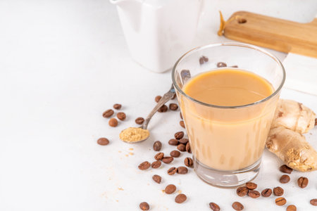 Fresh brewed ginger coffee latte cup. Creamy hot drink with ginger powder and ginger root, on white background. Healthy hot beverage. alternative medicine, remedyの写真素材