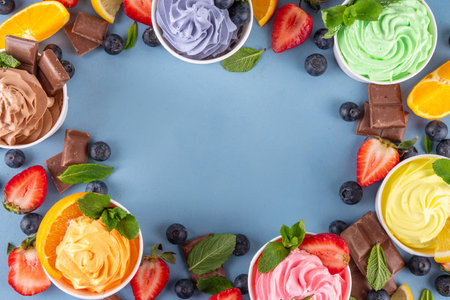 Frozen yogurt assortment. Soft creamy ice cream with chocolate, vanilla, berry, fruit flavors. Various tastes frozen yogurt cup with ingredients - blueberry, chocolate, strawberry, orange, lemon, mintの写真素材