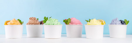 Frozen yogurt assortment. Soft creamy ice cream with chocolate, vanilla, berry, fruit flavors. Various tastes frozen yogurt cup with ingredients - blueberry, chocolate, strawberry, orange, lemon, mintの写真素材