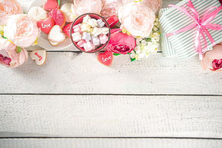 Valentine day background with Tender Pink Red White Peony Flowers and Heart Shaped Valentine Day Decor, Wooden White Background copy spaceの写真素材