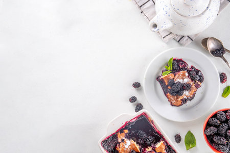 Sweet homemade mulberry cobbler pie, Sweet summer berry cobbler cake in enamel baking dish and plate, on white kitchen table copy spaceの写真素材