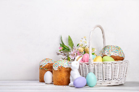 Traditional Easter basket with Easter cake, colorful pastel colored eggs, bunny rabbits decor and spring flower. Preparation for Easter celebration, greeting card, invitation, Easter sale backgroundの写真素材