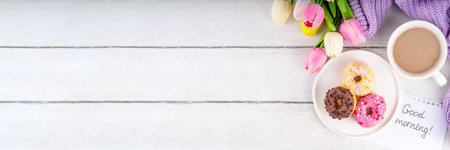 Small sugar glazed donuts with coffee latte cup, tulip flowers, sweater, tulip flower bouquet and note Good Morning. Spring holiday, Mother Day, Woman day, Birthday greeting card backgroundの写真素材