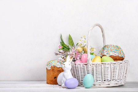 Traditional Easter basket with Easter cake, colorful pastel colored eggs, bunny rabbits decor and spring flower. Preparation for Easter celebration, greeting card, invitation, Easter sale backgroundの写真素材