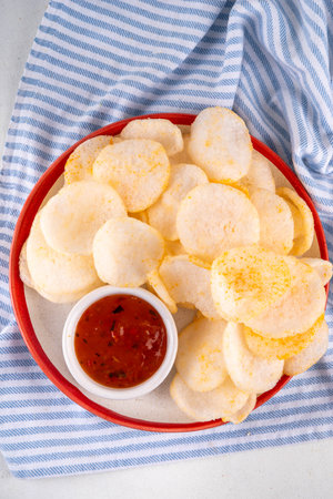Crispy airy rice shrimp chips. Fragrant prawn crackers with sauce, traditional Asian fast food snack, junk food healthier alternativeの写真素材