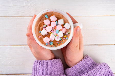 Hot sweet drinks for Easter party, breakfast, lunch. Easter menu. Pink, yellow, blue, brown multicolored hot chocolate cups with marshmallows, chocolate drawing rabbit, Easter eggs on latte surfaceの写真素材