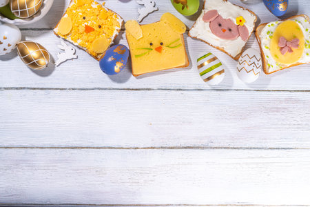 Cute funny Easter breakfast for kids. Homemade sandwiches, sandwiches in the form of symbols of the Easter holiday - Sheep, bunny rabbit, Easter egg, chicken.  top view copy spaceの写真素材