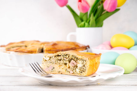 Easter Savory Pizza Pie, Traditional Italian Easter cake pizza Rustica with ham, salami, ricotta cheese, eggs and spinach, on festive decorated table, copy spaceの写真素材