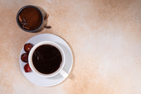 Healthy organic date seed coffee, black coffee cup, made with grated date seeds, with whole date fruits and seeds on beige background . Alternative coffee hot drinkの写真素材