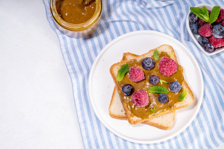 Pistachio paste toast. Summer breakfast delicious sandwiches with pistachio butter spread, with fresh berries. Balanced healthy vitamins and macronutrients snackの写真素材