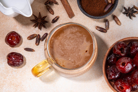 Healthy organic date seed coffee, coffee latte  cup, made with grated date seeds, with whole date fruits and seeds on beige background . Alternative coffee hot drinkの写真素材