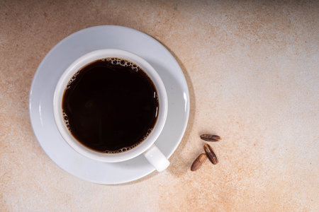 Healthy organic date seed coffee, black coffee cup, made with grated date seeds, with whole date fruits and seeds on beige background . Alternative coffee hot drinkの写真素材