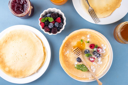 Traditional Maslenitsa food, Eastern European Slavic thin pancakes crepes, with various sweet spreads, toppings and fillings - honey, berries, jamsの写真素材