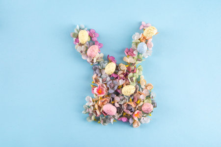 Easter spring holiday background with bunny rabbit made with flowers, creative diy Easter greeting...