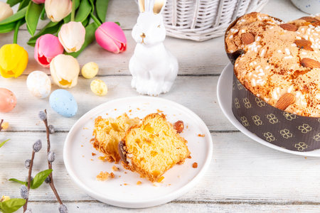 Italian Easter Colomba Cake, Colomba di Pasqua, sweet sugared dove-shaped sponge cake with glazed nuts and fruits, festive fruit- stuffed bread on white Easter holiday decorated table copy spaceの写真素材