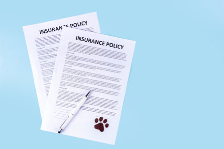 Pet health life Insurance, medical coverage concept. Insurance contract with cat paw signature and cute striped tabby cat. Flat lay mock-up for cats and dogs for insurance agency, medical servicesの写真素材