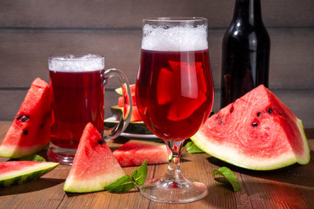 Glasses with tasty Sweet fruit berry watermelon Craft Beer, Cider or Ale on wooden table with fresh  watermelon slicesの写真素材