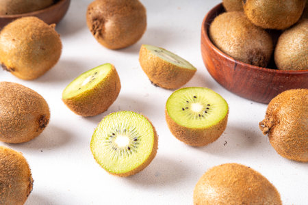 Sweet kiwi fruits, whole and sliced, on kitchen table copy space. Green and golden kiwi assortmentの写真素材