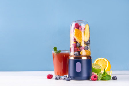 Healthy fruit and berry smoothie drink in portable portioned blender, Juicer Cup for smoothie, juice and shakes. Fruits in transparent blender cup and on table background, glass with fresh fruit shakeの写真素材