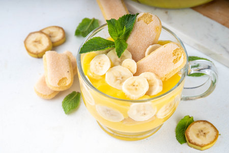 Banana Pudding Dessert on Glass cup. Layered parfait dessert with cookies and banana slices, copy spaceの写真素材