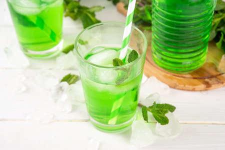 Middle Wastern limonana cocktail, mint liqueur lemonade, Lebanese mint lemonade drink, with crushed ice on white kitchen table background, copy spaceの写真素材