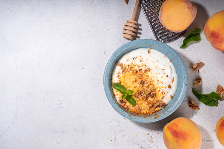 Frozen Shaved Peaches and Cream Dessert, Healthy summer snack with cream or yogurt and shaver frozen peach fruits, with nuts, honey and mint, copy spaceの写真素材