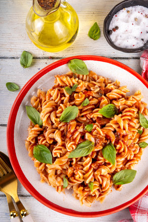 Fusilli pasta with bolognese sauce, with ground beef, mushrooms, tomatoes and basil. Traditional Italian lunch pasta plate, with spices served on the table copy spaceの写真素材