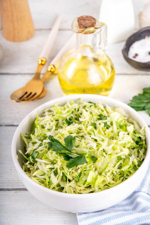 Spring cabbage salad, vegan healthy diet vegetable food, salad with spring cabbage, parsley, green onions, olive oil for dressingの写真素材