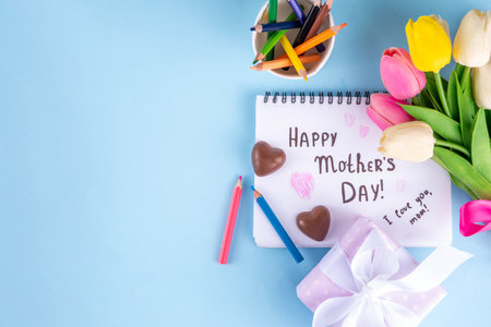 Mother day greeting card, brunch or party invitation background, Spring bouquet of tulip flower, with gift bow and note Happy Mothers day, copy space on colorful light blue backgroundの写真素材