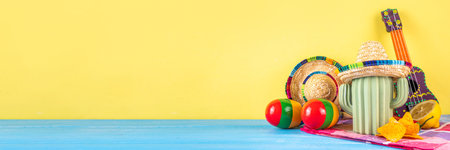 Cinco de Mayo holiday background with Mexican cactus decor, party sombrero hat, nachos chips, guitar, maracas. Cinco de Mayo holiday celebration greeting card, copy spaceの写真素材